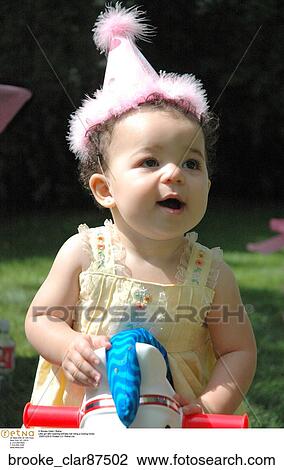 Little girl latin wearing birthday hat riding a rocking horse View Large Photo Image Stock Image - Little girl latin wearing birthday hat riding a rocking horse. Fotosearch