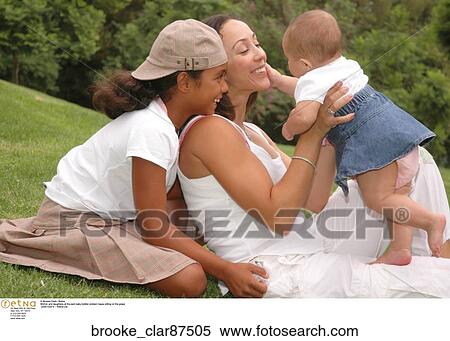 Mother and daughters at the park baby toddler preteen happy sitting on the grass View Large Photo Image Stock Photography - Mother and daughters at the park baby toddler preteen happy sitting on the grass. Fotosearch