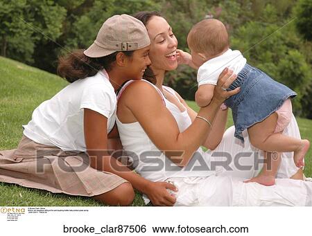 Mother and daughters sitting at the park laughing toddler baby preteen grass spring View Large Photo Image Stock Photograph - Mother and daughters sitting at the park laughing toddler baby preteen grass spring. Fotosearch