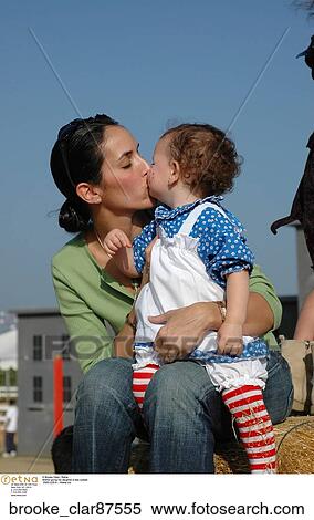 Stock Photography - Mother giving her daughter a kiss outside. Fotosearch