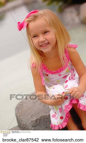 Portrait of a little girl in a dress with a ribbon in her hair smiling View Large Photo Image Stock Image - Portrait of a little girl in a dress with a ribbon in her hair smiling. Fotosearch
