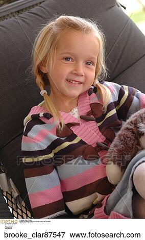 Portrait of a little girl wearing a sweater smiling with ponytails View Large Photo Image Stock Photo - Portrait of a little girl wearing a sweater smiling with ponytails. Fotosearch