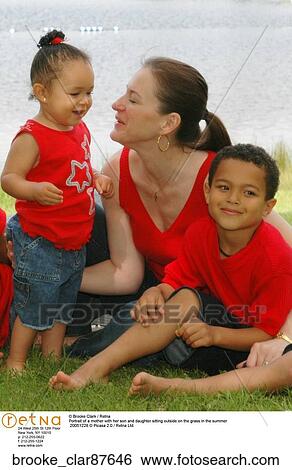 Portrait of a mother with her son and daughter sitting outside on the grass in the summer View Large Photo Image Stock Photograph - Portrait of a mother with her son and daughter sitting outside on the grass in the summer. Fotosearch