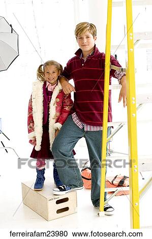 Portrait of a teenage boy and a young girl posing by a ladder the girl stands on a box. View Large Photo Image Stock Image - Portrait of a teenage boy and a young girl posing by a ladder the girl stands on a box.. Fotosearch