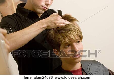 Portrait of a teenage boy having a haircut in a salon. View Large Photo Image Stock Photograph - Portrait of a teenage boy having a haircut in a salon.. Fotosearch