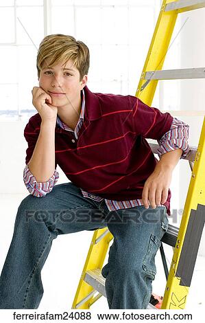 Portrait of a teenage boy sitting on a ladder in front of a window. View Large Photo Image Stock Photo - Portrait of a teenage boy sitting on a ladder in front of a window.. Fotosearch