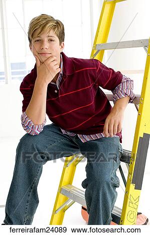 Portrait of a teenage boy sitting on a ladder in front of a window View Large Photo Image Stock Photo - Portrait of a teenage boy sitting on a ladder in front of a window. Fotosearch