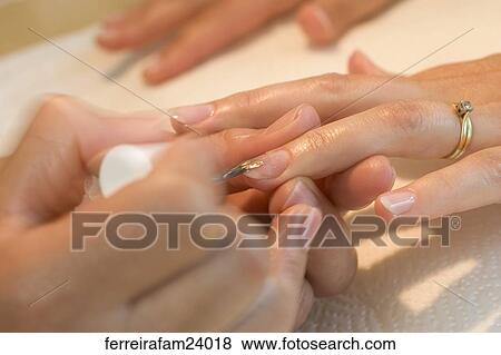 Portrait of a woman in her 30's getting a manicure in a salon. View Large Photo Image Stock Photo - Portrait of a woman in her 30's getting a manicure in a salon.. Fotosearch