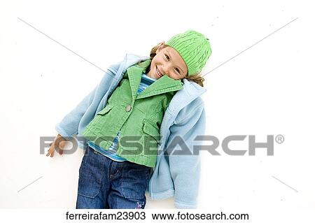 Portrait of a young girl lying on a white backdrop wearing a blue coat and green hat View Large Photo Image Stock Image - Portrait of a young girl lying on a white backdrop wearing a blue coat and green hat. Fotosearch