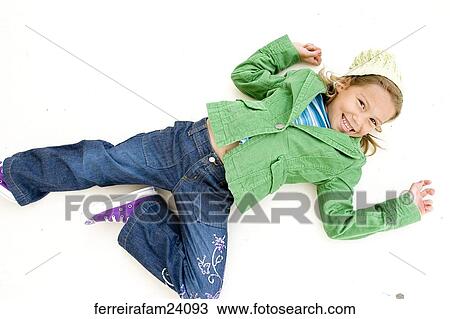 Portrait of a young girl lying on a white backdrop wearing a green coat and green hat and purple sneakers. View Large Photo Image Stock Image - Portrait of a young girl lying on a white backdrop wearing a green coat and green hat and purple sneakers.. Fotosearch