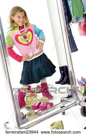 Portrait of a young girl posing in front of a mirror with colorful clothing View Large Photo Image Picture - Portrait of a young girl posing in front of a mirror with colorful clothing. Fotosearch