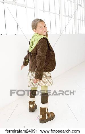Portrait of a young girl standing in front of a window wearing winter clothing View Large Photo Image Stock Image - Portrait of a young girl standing in front of a window wearing winter clothing. Fotosearch