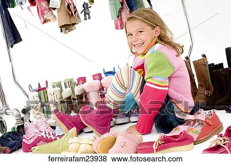 Portrait of a young girl trying on shoes posing with colorful clothing. View Large Photo Image Stock Photo - Portrait of a young girl trying on shoes posing with colorful clothing.. Fotosearch