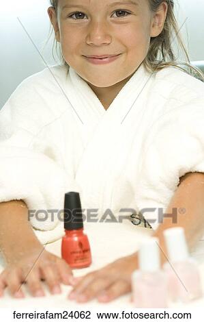 Portrait of a young girl wearing a white robe getting a manicure in a salon. View Large Photo Image Stock Image - Portrait of a young girl wearing a white robe getting a manicure in a salon.. Fotosearch