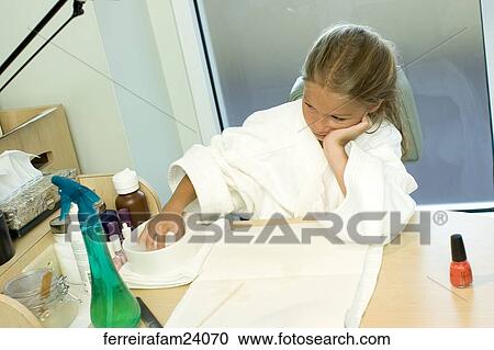 Portrait of a young girl wearing a white robe getting a manicure in a salon View Large Photo Image Stock Image - Portrait of a young girl wearing a white robe getting a manicure in a salon. Fotosearch