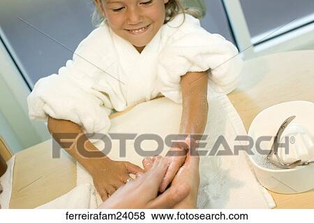Portrait of a young girl wearing a white robe getting a manicure in a salon. View Large Photo Image Stock Photo -  Portrait of a young girl wearing a white robe getting a manicure in a salon.. Fotosearch