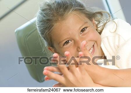 Portrait of a young girl wearing a white robe getting a manicure in a salon. View Large Photo Image Stock Photo - Portrait of a young girl wearing a white robe getting a manicure in a salon.. Fotosearch