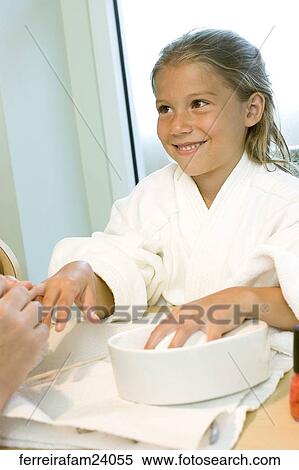 Portrait of a young girl wearing a white robe getting a manicure in a salon View Large Photo Image Stock Photography - Portrait of a young girl wearing a white robe getting a manicure in a salon. Fotosearch