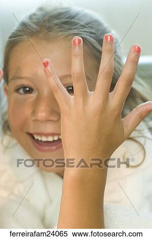 Stock Photography -  Portrait of a young girl wearing a white robe getting a manicure in a salon. Fotosearch