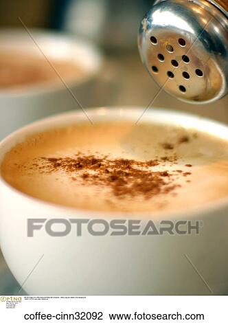 Still life image of a coffee being sprinkled with cinnamon. Other cups are visible in the background. View Large Photo Image Stock Image - Still life image of a coffee being sprinkled with cinnamon. Other cups are visible in the background.. Fotosearch