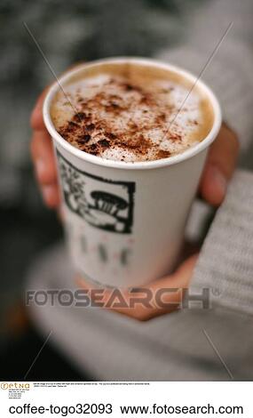 Still life image of a cup of coffee with foam and cinnamon sprinkled on top. The cup is a cardboard and being held in someones hands. View Large Photo Image Stock Image - Still life image of a cup of coffee with foam and cinnamon sprinkled on top. The cup is a cardboard and being held in someones hands.. Fotosearch