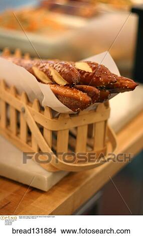 Still life indoor image of a basket of loaf/ loaves of bread wrapped in paper. View Large Photo Image Picture - Still life indoor image of a basket of loaf/ loaves of bread wrapped in paper. . Fotosearch