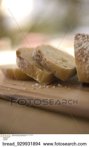 Still life indoor image of a loaf of bread sliced sitting on a cutting board. View Large Photo Image Picture - Still life indoor image of a loaf of bread sliced sitting on a cutting board.. Fotosearch