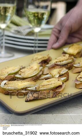 Still life indoor image of a serving tray of bruchetta being held to view with glasses of white wine visible behind it. View Large Photo Image Stock Image - Still life indoor image of a serving tray of bruchetta being held to view with glasses of white wine visible behind it.. Fotosearch