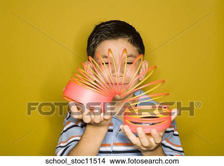 Stock images of science related topics Latin boy Student playing with a slinky View Large Photo Image Picture - Stock images of science related topics Latin boy Student playing with a slinky. Fotosearch
