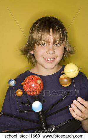 Stock Image -  Stock images of science related topics boy student wearing an blue shirt showing off his solar system school project.. Fotosearch
