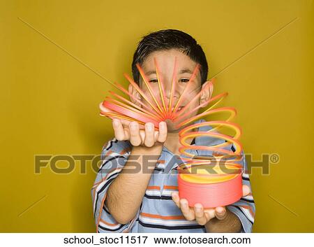 Stock images of science related topics Latin boy Student playing with a slinky View Large Photo Image Stock Photo - Stock images of science related topics Latin boy Student playing with a slinky. Fotosearch