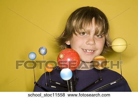 Stock Photo -  Stock images of science related topics boy student wearing an blue shirt showing off his solar system school project.. Fotosearch