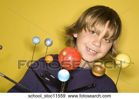 Stock Photo -  Stock images of science related topics boy student wearing an blue shirt showing off his solar system school project.. Fotosearch