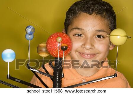 Stock images of science related topics latin boy student wearing an orange shirt showing off his solar system school project. View Large Photo Image Stock Photo - Stock images of science related topics latin boy student wearing an orange shirt showing off his solar system school project.. Fotosearch