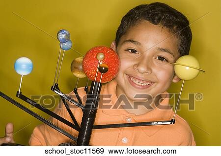 Stock images of science related topics latin boy student wearing an orange shirt showing off his solar system school project. View Large Photo Image Stock Photo - Stock images of science related topics latin boy student wearing an orange shirt showing off his solar system school project.. Fotosearch