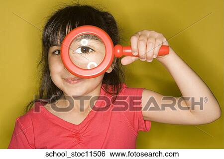 Stock images of science related topics Girl Student peers through a magnifying glass. she's wearing a pink shirt and has her hair pulled into pigtails. View Large Photo Image Stock Photograph - Stock images of science related topics Girl Student peers through a magnifying glass. she's wearing a pink shirt and has her hair pulled into pigtails.. Fotosearch