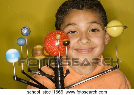 Stock Photograph -  Stock images of science related topics latin boy student wearing an orange shirt showing off his solar system school project.. Fotosearch
