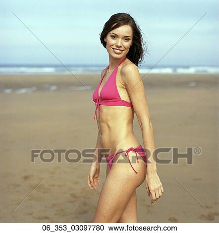 Summer BeautyWoman walking on a beach wearing a pink halterneck bikini View Large Photo Image Stock Image - Summer BeautyWoman walking on a beach wearing a pink halterneck bikini . Fotosearch