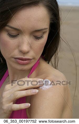Summer BeautyWoman wearing a pink halterneck bikini rubbing cream into her shoulders View Large Photo Image Stock Image - Summer BeautyWoman wearing a pink halterneck bikini rubbing cream into her shoulders . Fotosearch