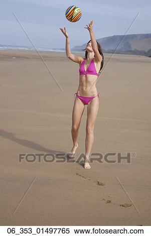 Summer FitnessWoman wearing a pink halterneck bikini throwing a spiral coloured ball into the View Large Photo Image Stock Photography - Summer FitnessWoman wearing a pink halterneck bikini throwing a spiral coloured ball into the. Fotosearch