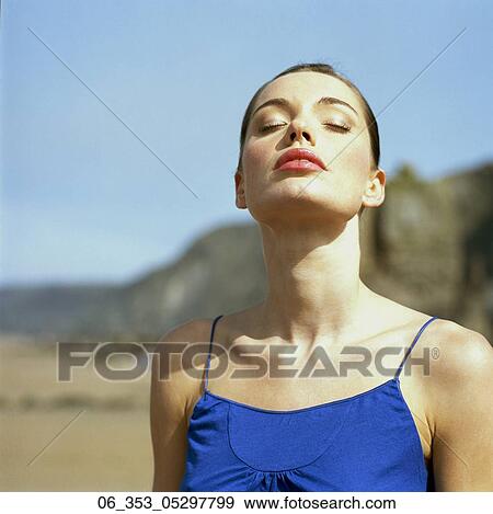 Woman BeachWoman standing on a beach wearing a blue vest eyes closed breathing in the air View Large Photo Image Stock Photo - Woman BeachWoman standing on a beach wearing a blue vest eyes closed breathing in the air . Fotosearch