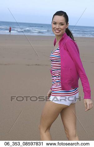 Woman BeachWoman walking on a beach wearing a stripey vest top white hotpant shorts and pink cardigan View Large Photo Image Stock Image - Woman BeachWoman walking on a beach wearing a stripey vest top white hotpant shorts and pink cardigan . Fotosearch