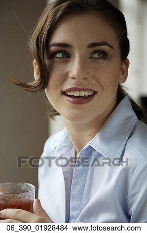 Woman DrinkingWoman wearing a blue shirt drinking from a glass mug View Large Photo Image Picture - Woman DrinkingWoman wearing a blue shirt drinking from a glass mug . Fotosearch