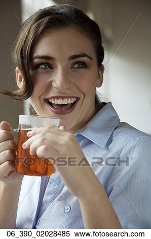 Woman DrinkingWoman wearing a blue shirt drinking from a glass mug View Large Photo Image Stock Photography - Woman DrinkingWoman wearing a blue shirt drinking from a glass mug . Fotosearch
