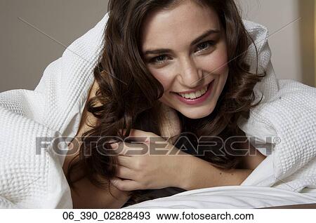 Woman in BedClose up of a woman in bed wrapped up in a white duvet View Large Photo Image Stock Image - Woman in BedClose up of a woman in bed wrapped up in a white duvet . Fotosearch