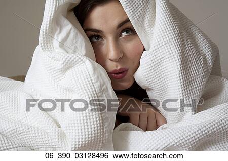 Woman in BedClose up of a woman in bed wrapped up in a white duvet pulling a silly face View Large Photo Image Stock Photograph - Woman in BedClose up of a woman in bed wrapped up in a white duvet pulling a silly face . Fotosearch