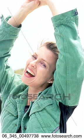 Woman OutsideWoman wearing a green denim jacket smiling with arms in the air View Large Photo Image Stock Photo - Woman OutsideWoman wearing a green denim jacket smiling with arms in the air . Fotosearch
