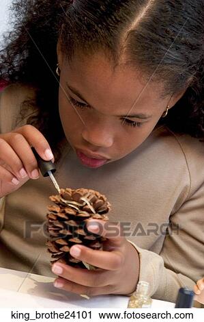 Young African American girl decorating a pine cone View Large Photo Image Stock Image - Young African American girl decorating a pine cone. Fotosearch
