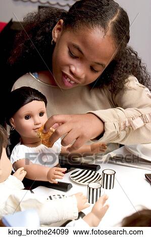 Young African American girl feeding her doll View Large Photo Image Stock Photo - Young African American girl feeding her doll. Fotosearch