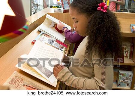 Young African American girl stading up reading a book View Large Photo Image Stock Photography - Young African American girl stading up reading a book. Fotosearch